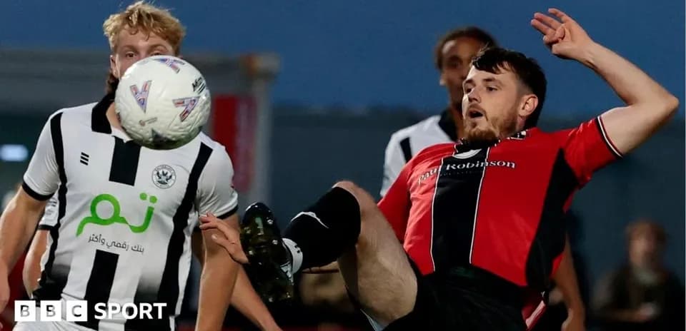 Player kicking ball during football match action