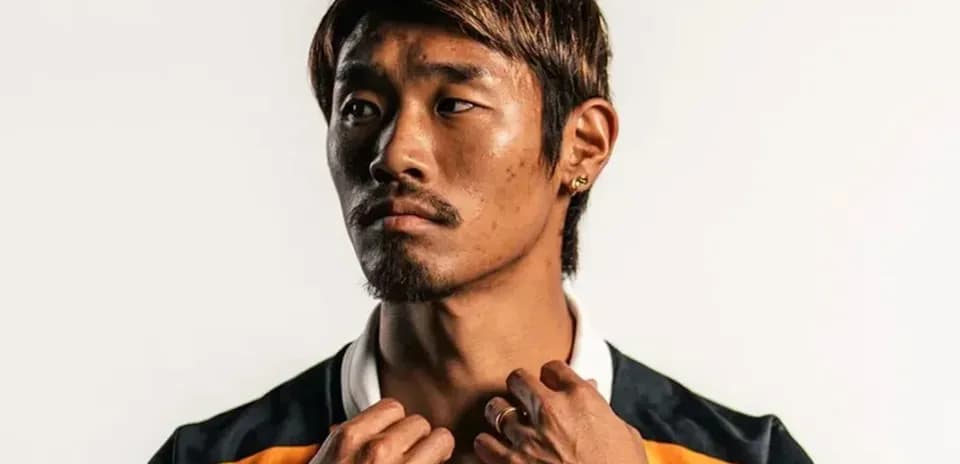 Athlete posing in sports jersey against neutral background