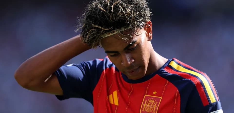 Player in Spain jersey looking down on pitch