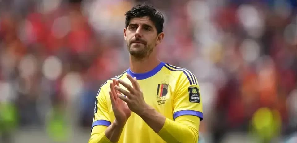Goalkeeper in yellow kit applauding fans after match