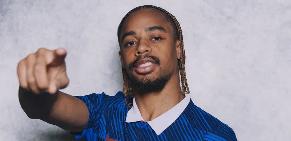 Player posing in blue jersey, pointing forward