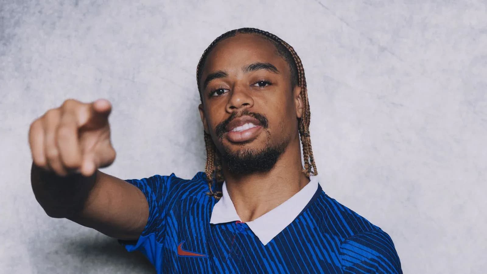 Player posing in blue jersey, pointing forward