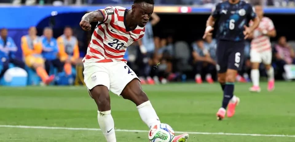 Player in striped jersey kicking soccer ball on field