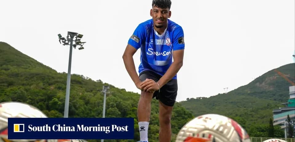 Football player posing with balls on training field