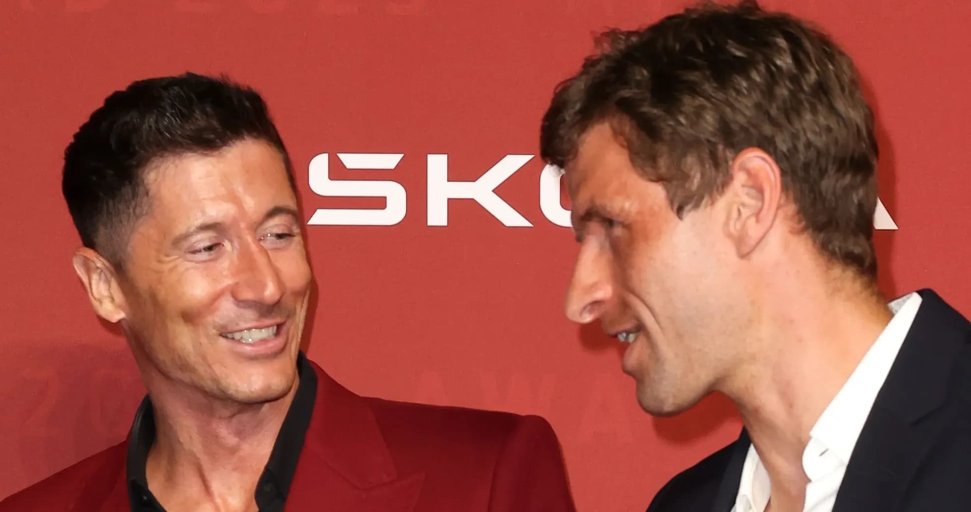 Two men conversing at a red carpet event