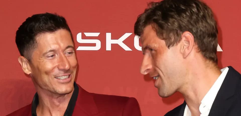 Two men conversing at a red carpet event