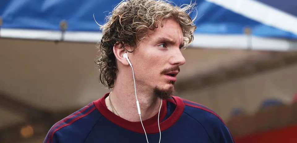 Athlete wearing headphones, walking in casual attire