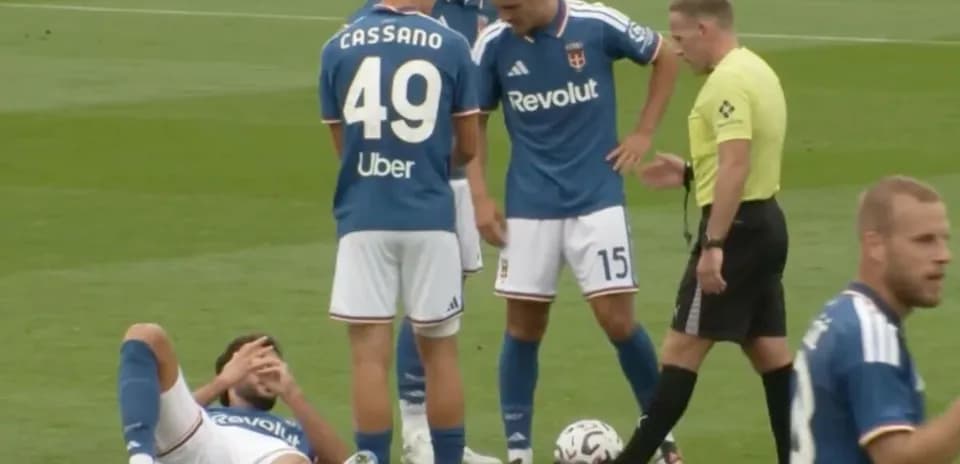 Players gathered around an injured teammate on field