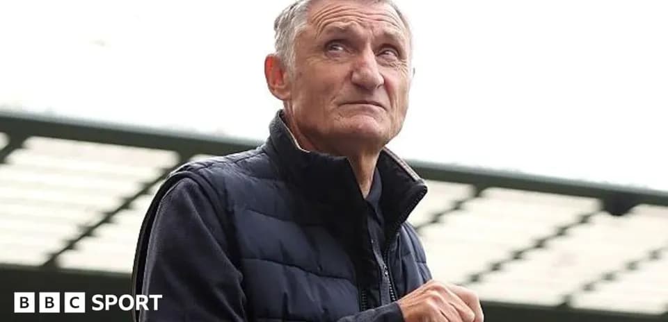Man in a vest looking thoughtfully at stadium