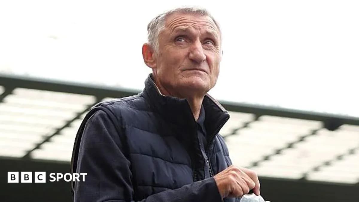 Man in a vest looking thoughtfully at stadium