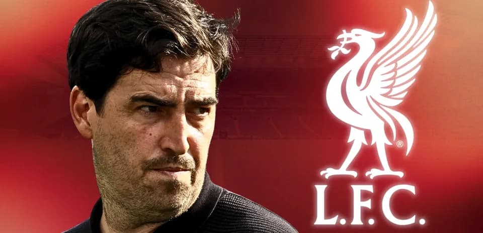 Coach in front of Liverpool FC logo background