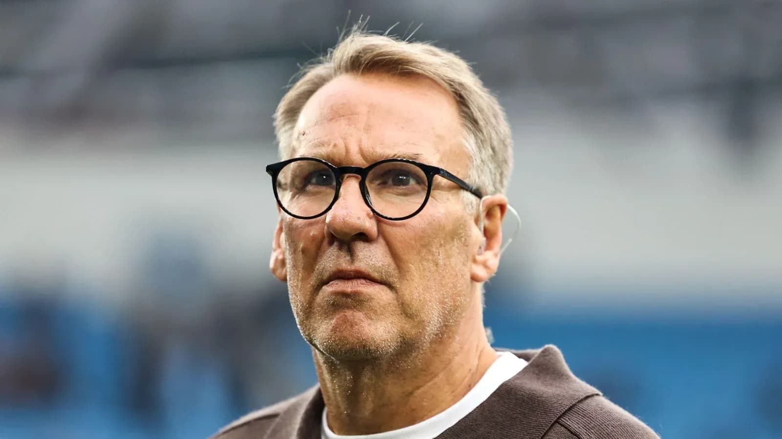 Man with glasses observing the football match