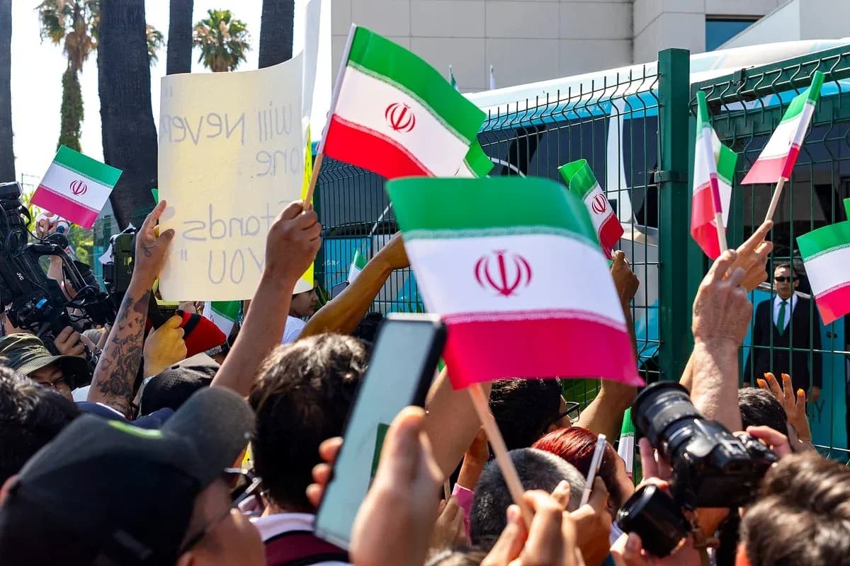 Crowd holding Iranian flags and signs at protest