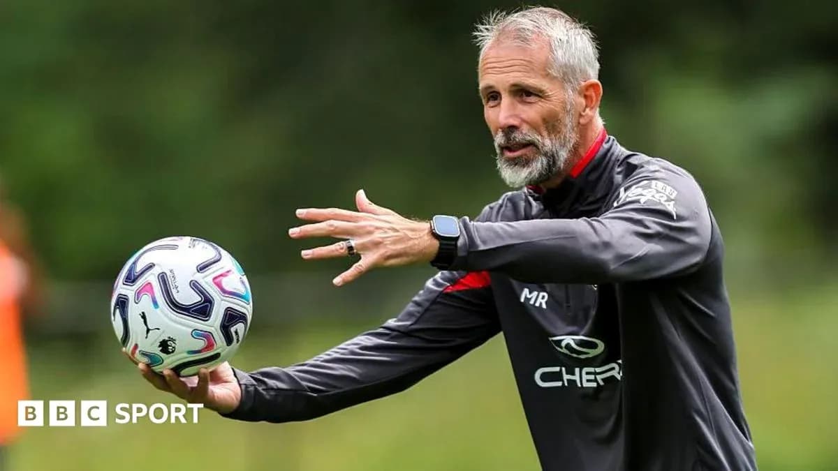 Coach demonstrating technique while holding a football