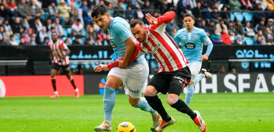 Athletic Club player challenging Celta Vigo opponent
