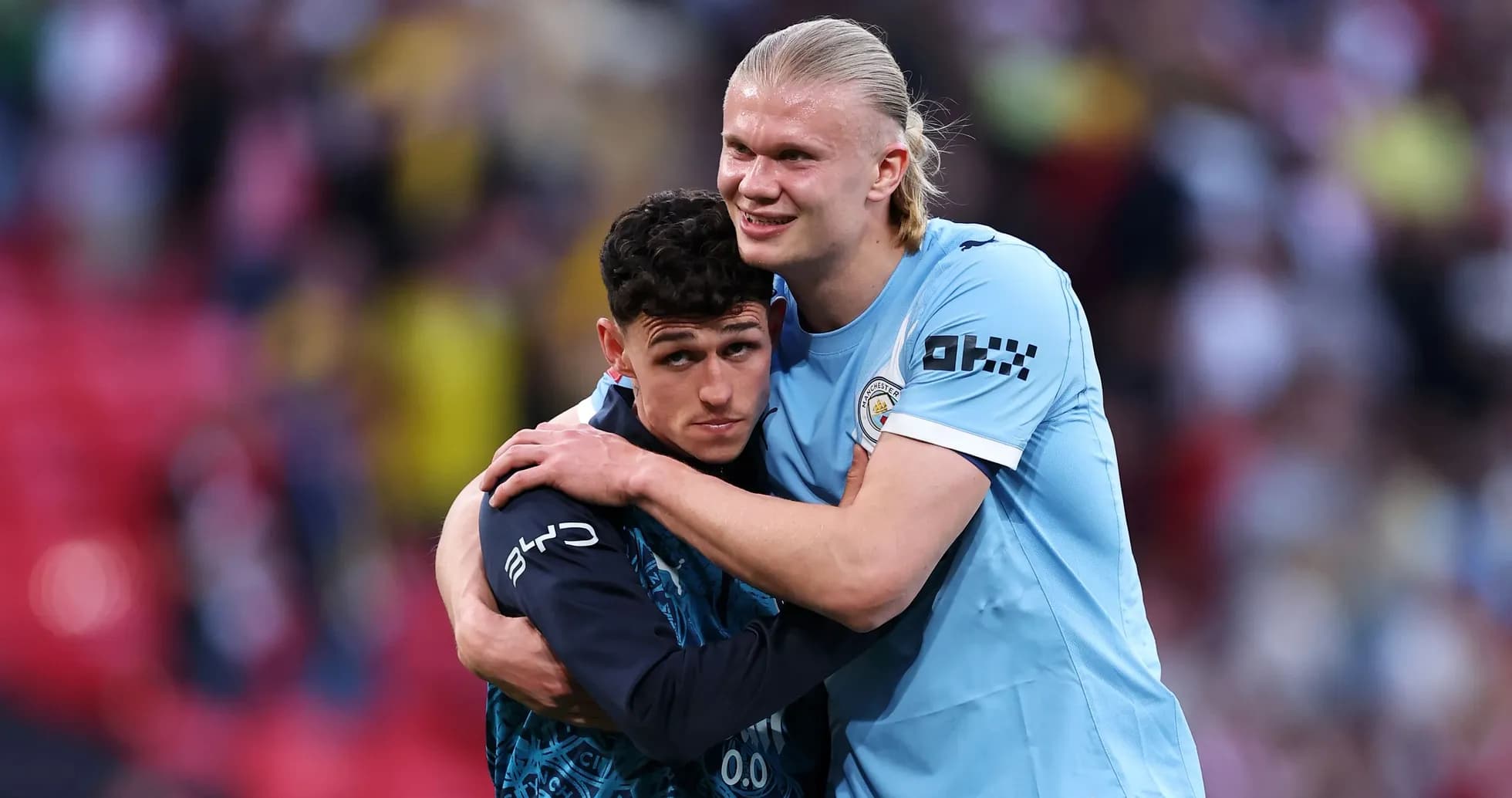 Two Manchester City players embracing on the pitch