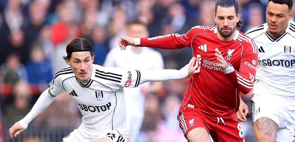 Fulham and Liverpool players competing for possession