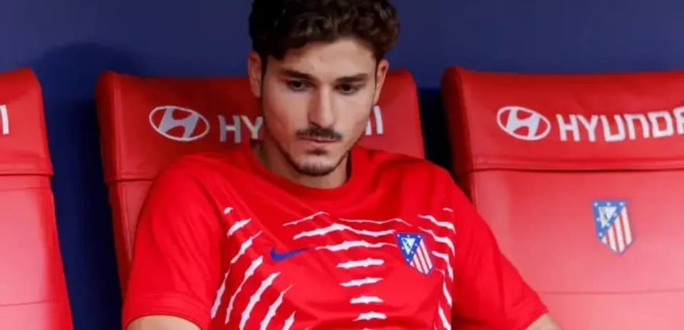 Player seated on bench wearing Atlético Madrid jersey
