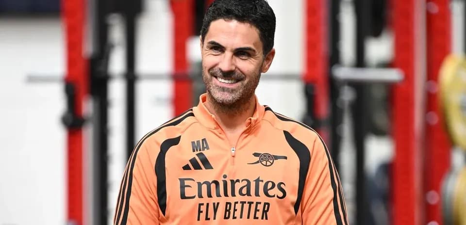 Coach in training gear smiling in gym setting