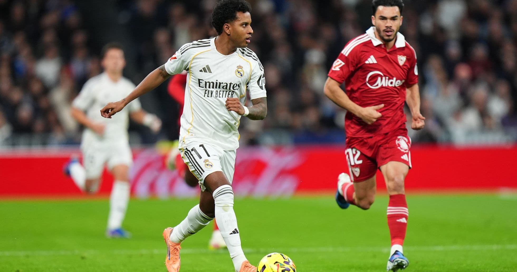 Real Madrid player dribbling past Sevilla defender