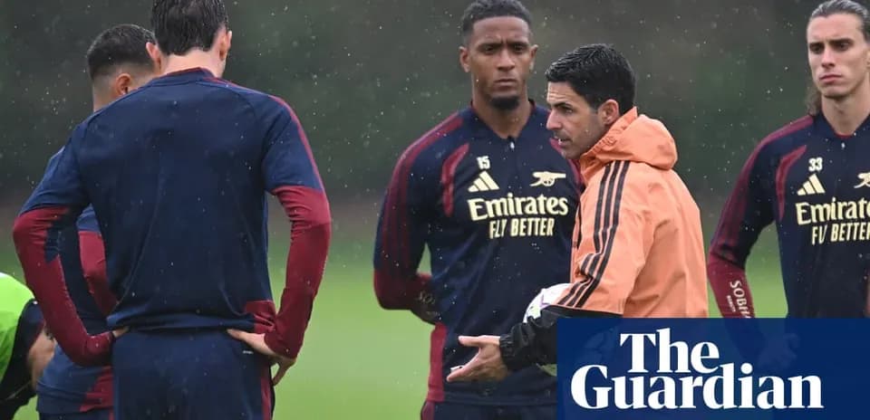 Manager instructing players during rainy training session