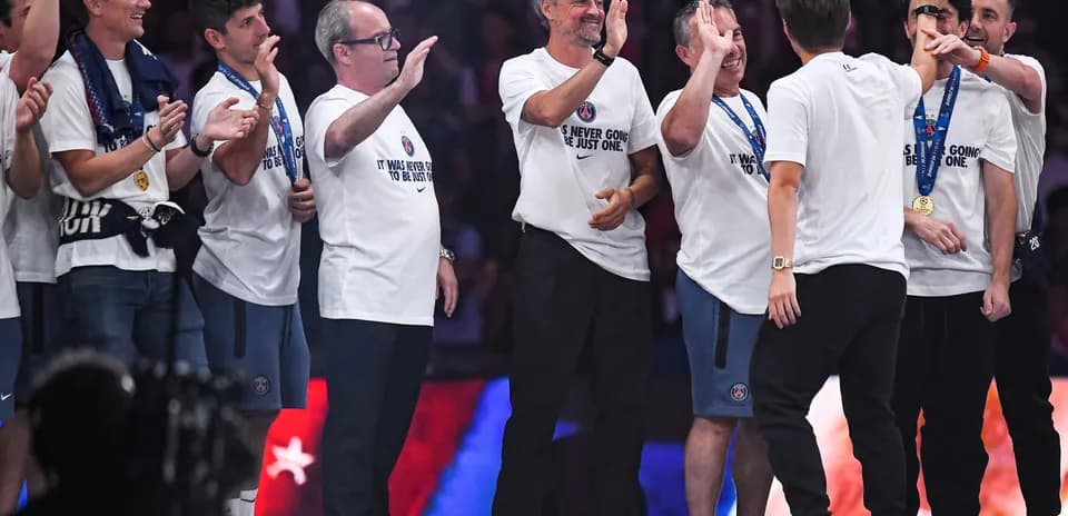 Coaching staff celebrating with team members on stage