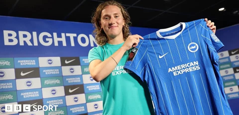 Player presenting Brighton jersey at press conference
