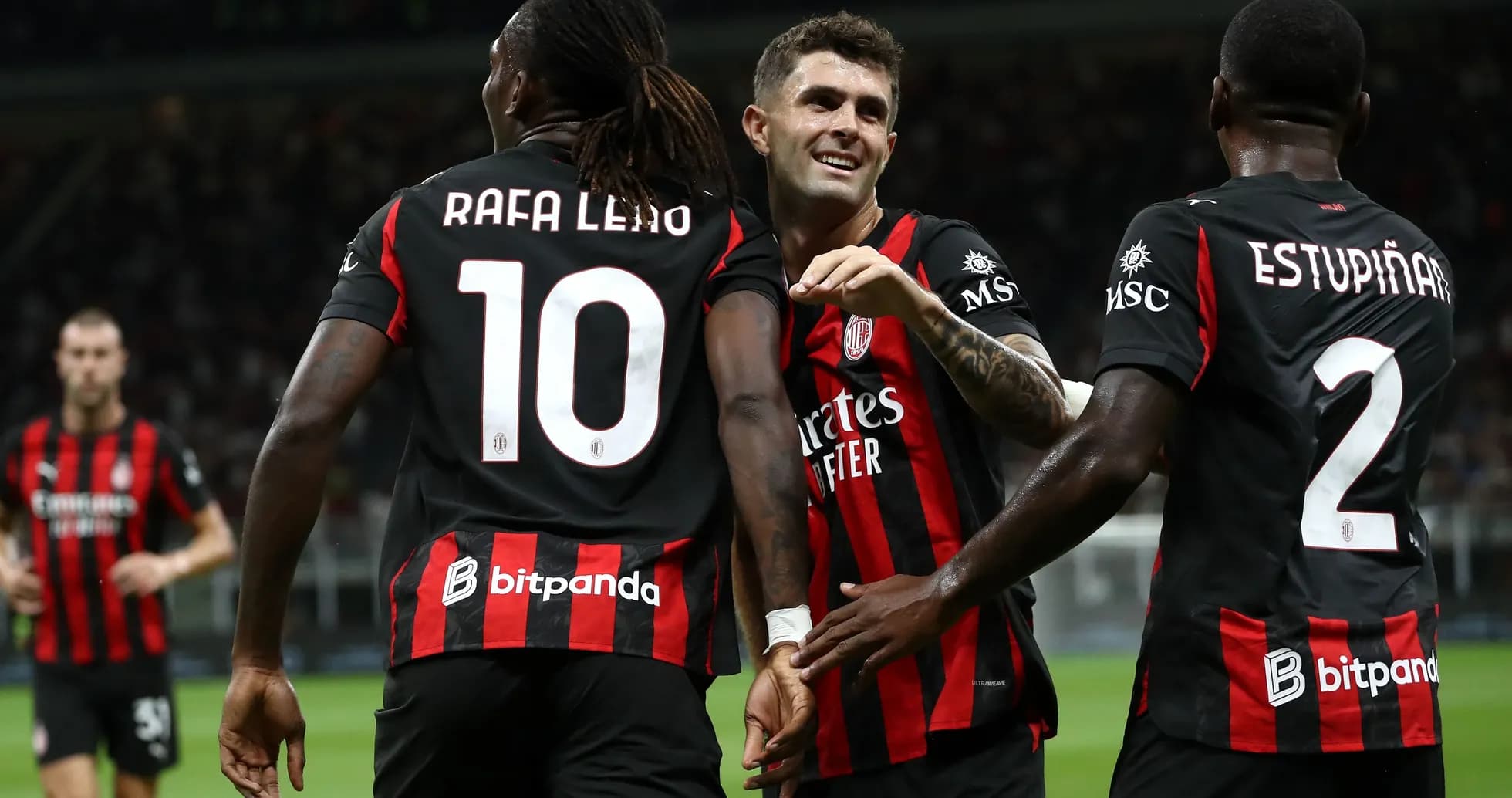 Players celebrating a goal in black and red jerseys