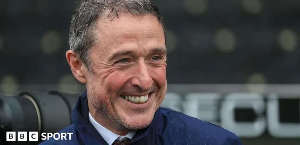 Smiling man in a raincoat at sports venue