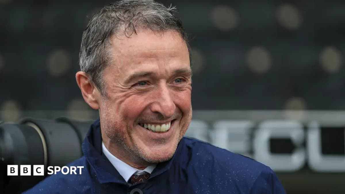 Smiling man in a raincoat at sports venue