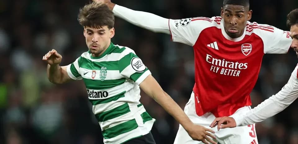 Arsenal player challenging Sporting CP opponent