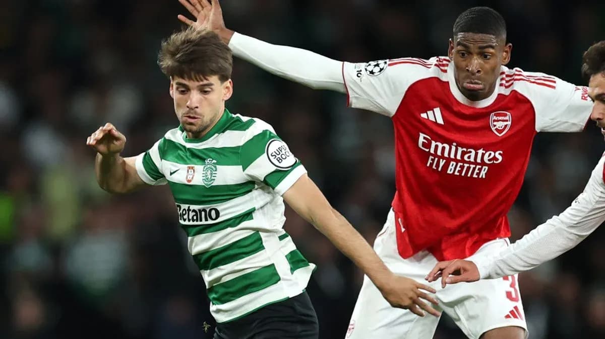 Arsenal player challenging Sporting CP opponent
