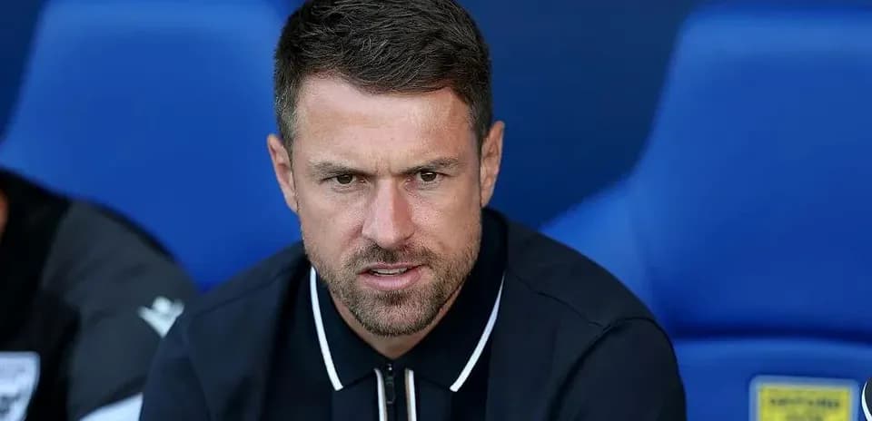 Coach seated on bench during match preparation