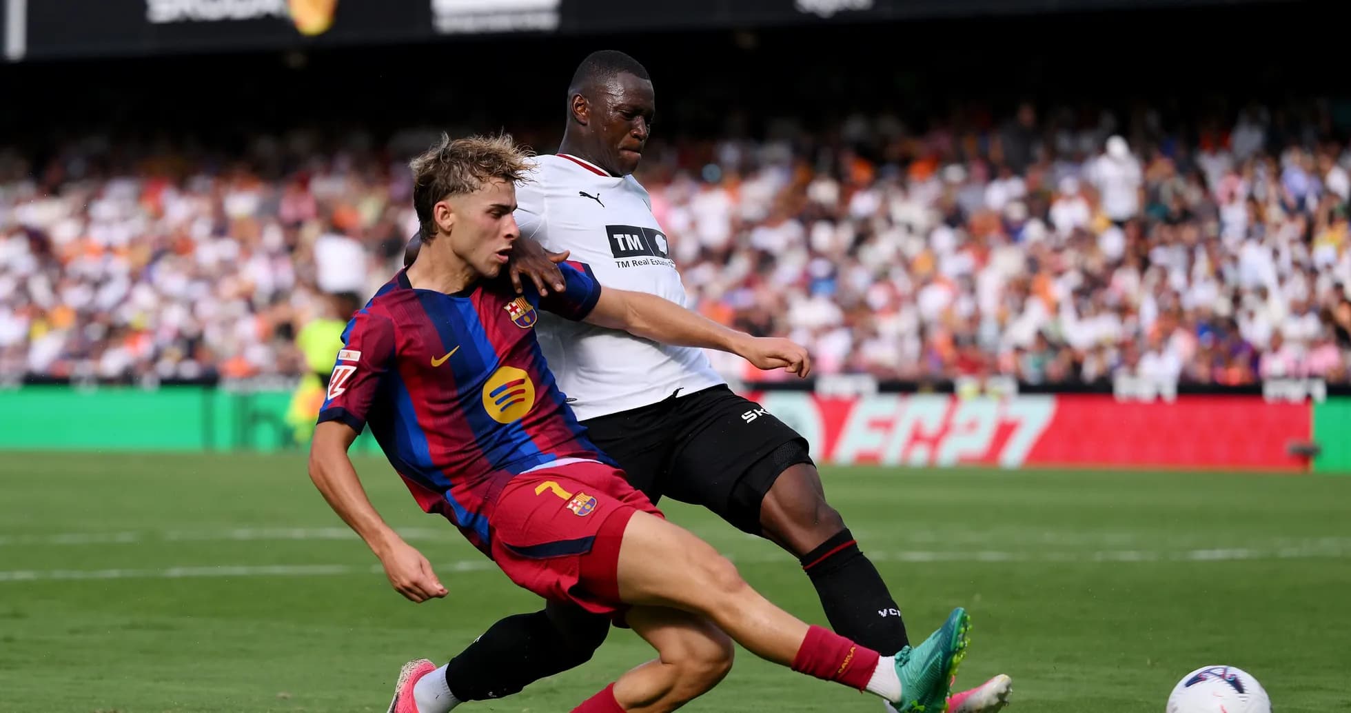 Player from FC Barcelona tackling opposing player