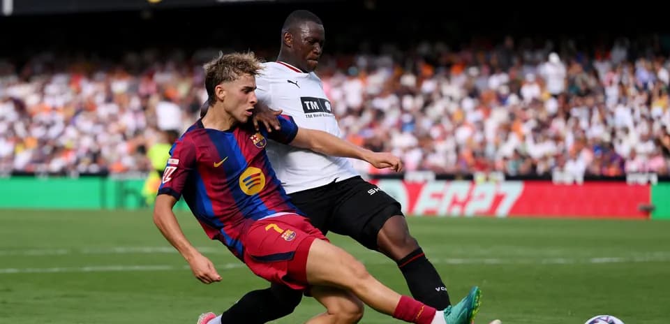 Player from FC Barcelona tackling opposing player