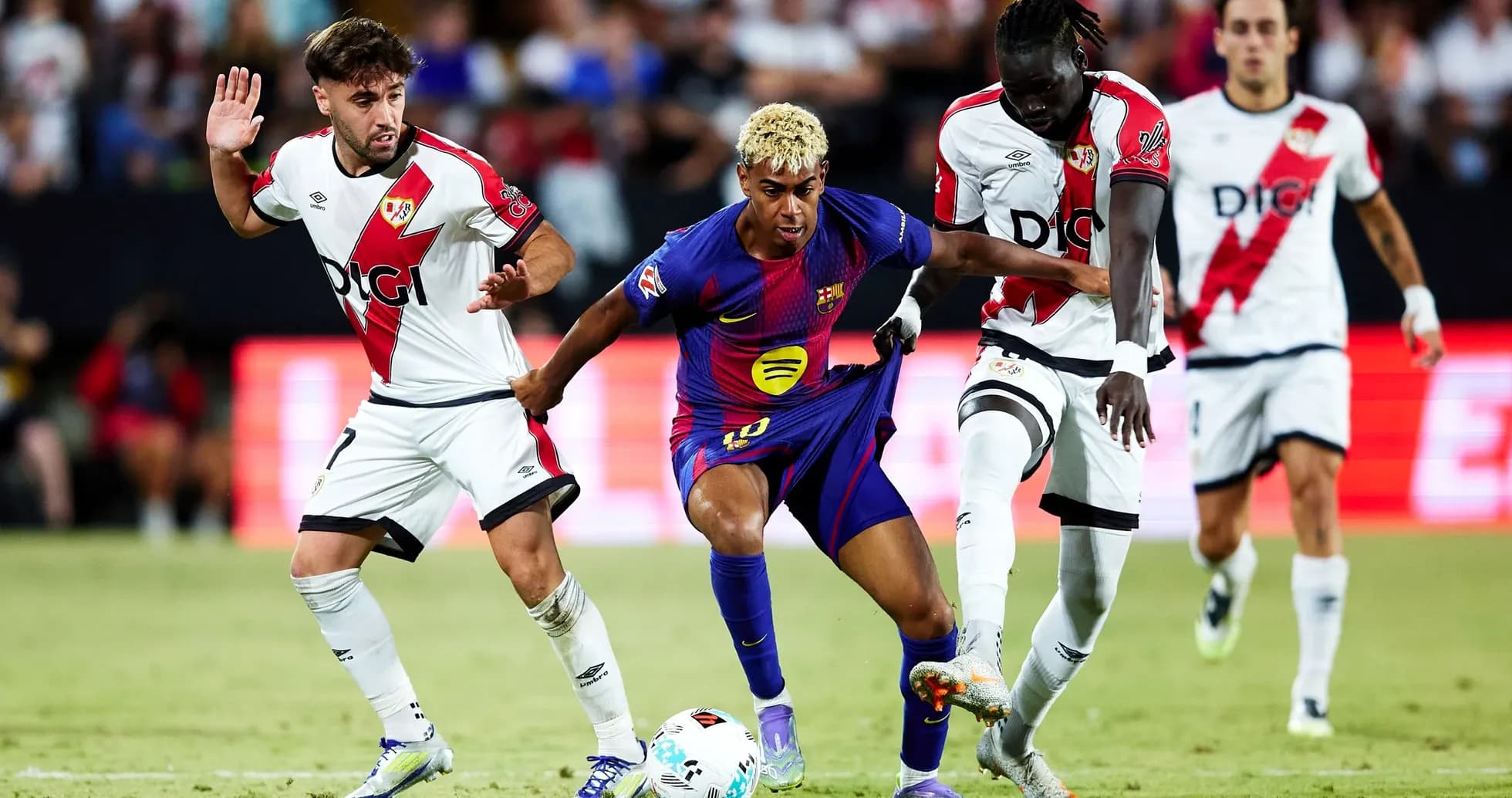 Barcelona player challenged by Rayo Vallecano defenders