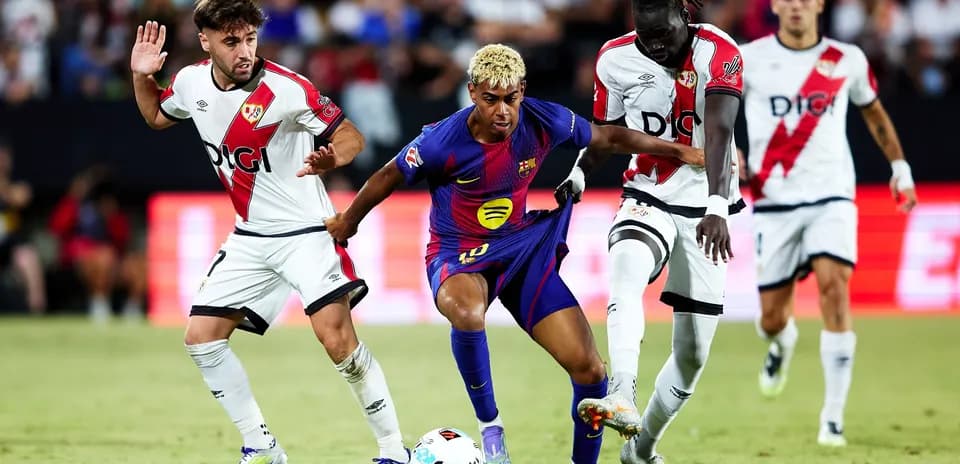 Barcelona player challenged by Rayo Vallecano defenders