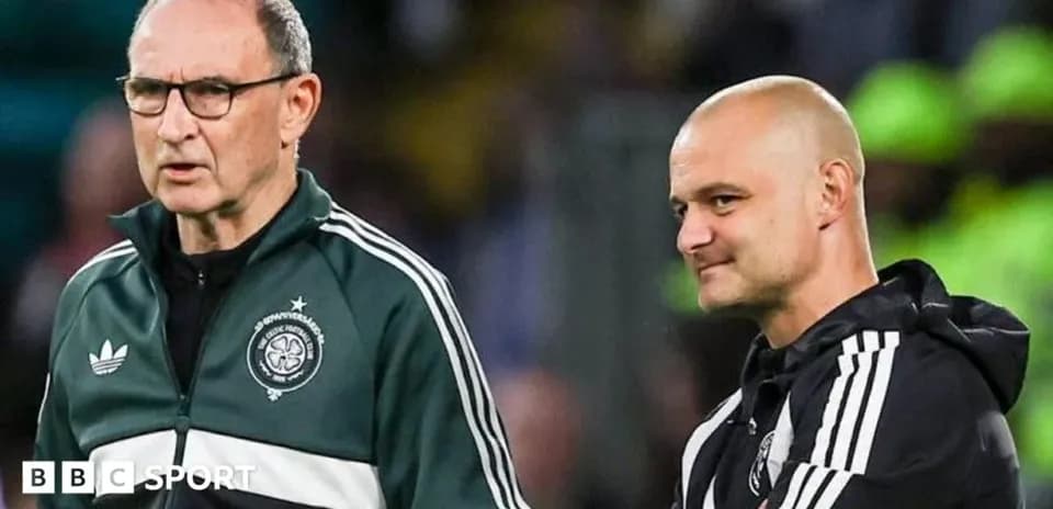 Two coaches discussing strategy on the sidelines