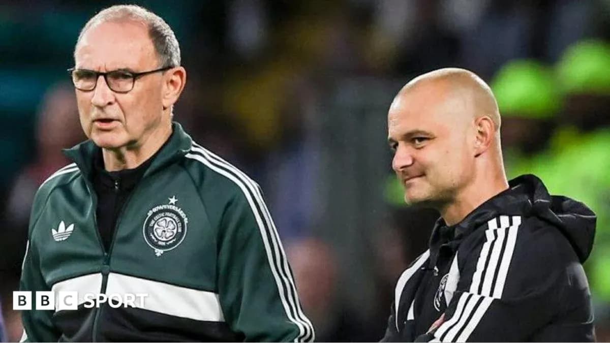 Two coaches discussing strategy on the sidelines