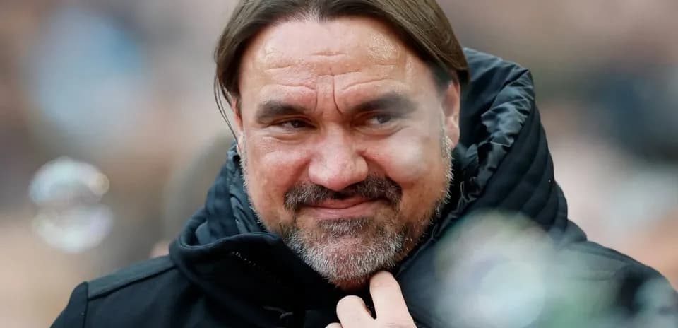 Man in black jacket with long hair smiling