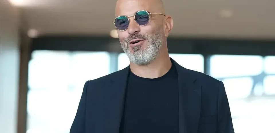 Man in sunglasses smiling in modern indoor setting