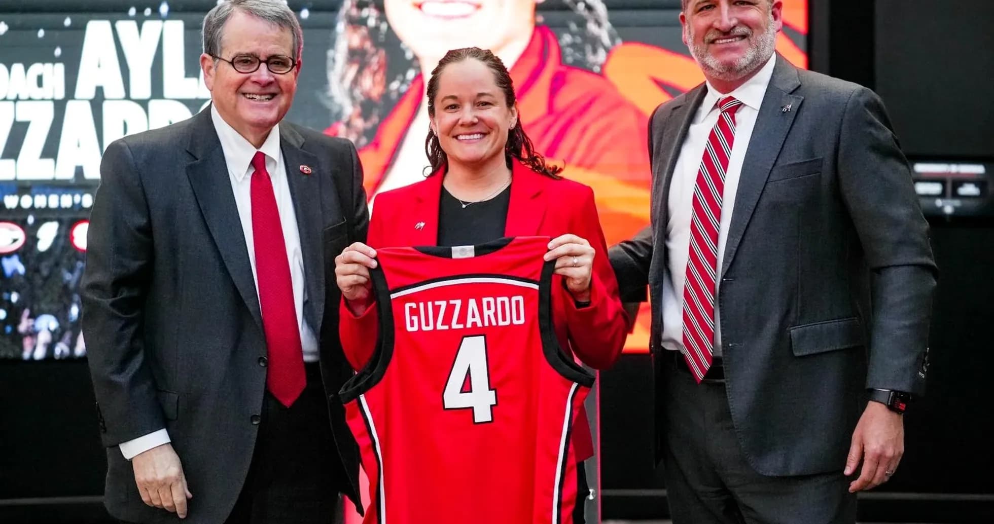 New coach holding jersey at press conference