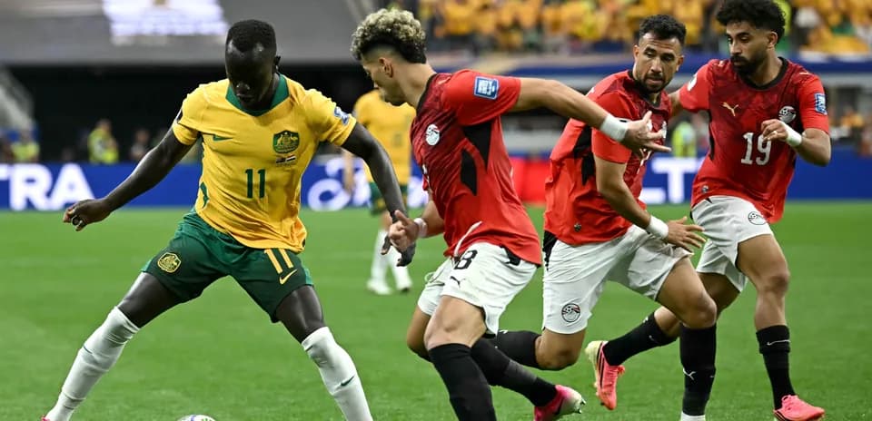 Player with ball surrounded by defenders during match