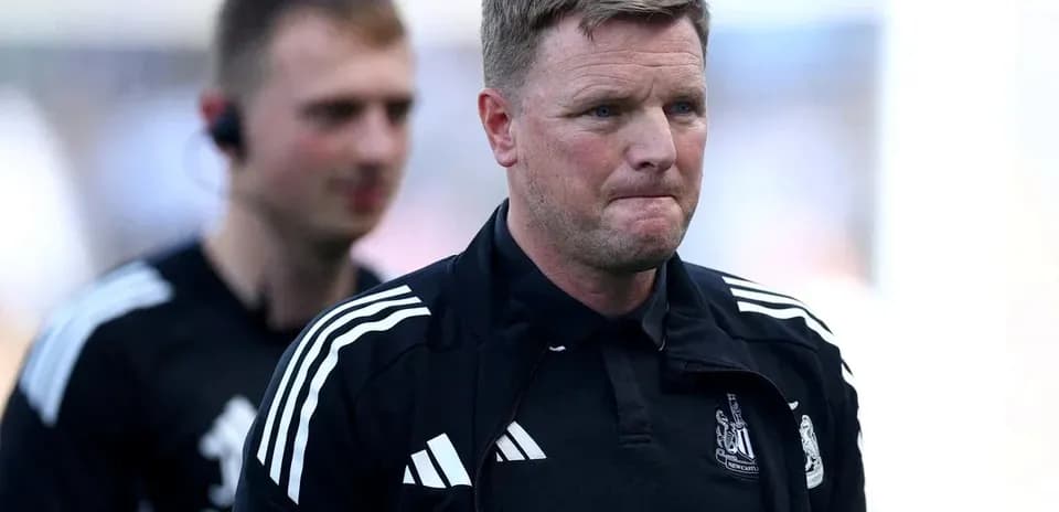 Manager walking on the pitch with assistant behind