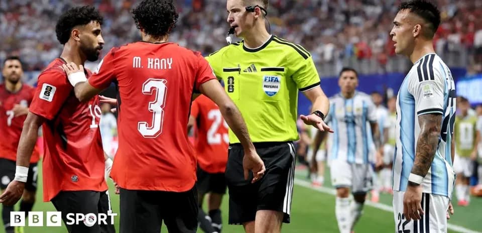 Players and referee discussing during match stoppage