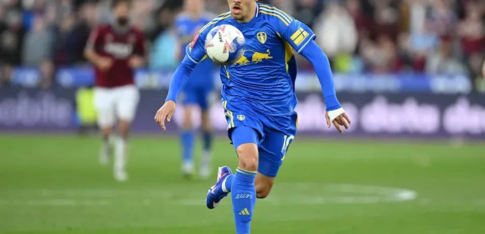 Player in blue kit dribbling the ball on field