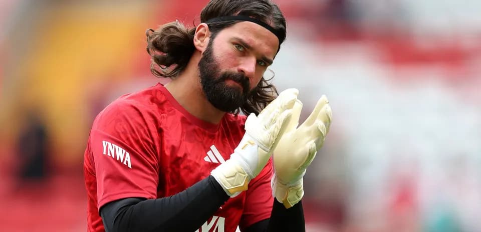 Goalkeeper clapping while wearing gloves and red jersey