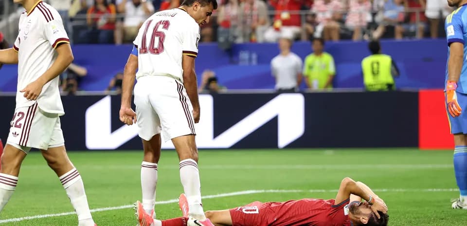 Player lying on field with teammates nearby