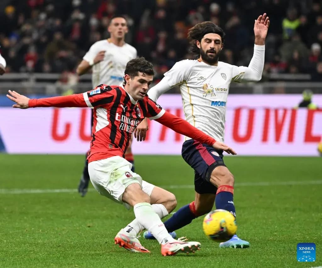 AC Milan player tackling Cagliari opponent