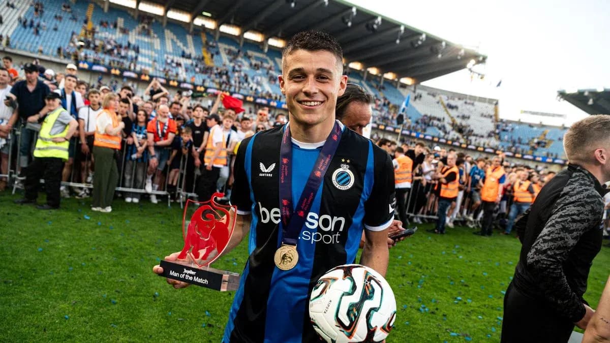 Player holding trophy and ball surrounded by fans